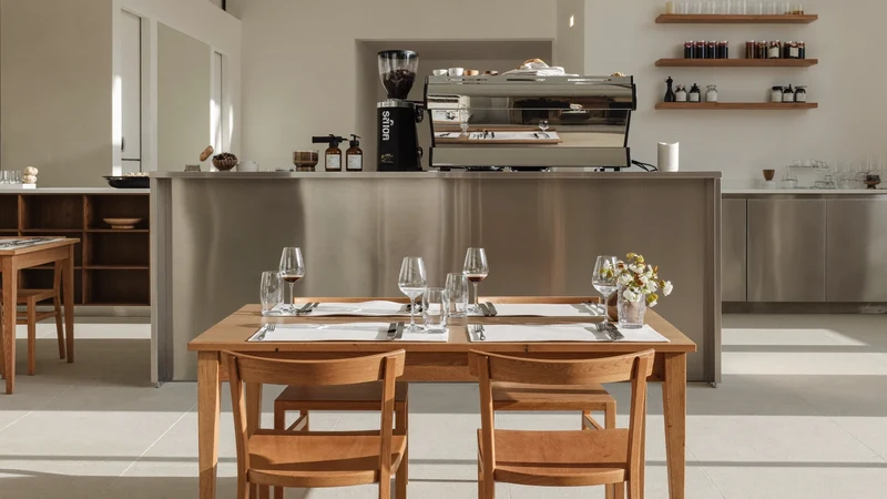 Interno luminoso di una caffetteria milanese al mattino, con tavoli in legno e macchina espresso